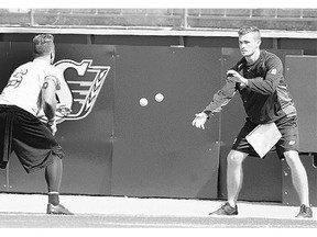 Saskatchewan Roughriders receiver Rob Bagg works on a tennis-ball drill with a coaching assistant during Tuesday's practice at Mosaic Stadium.