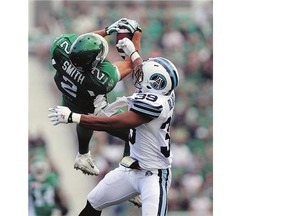 Saskatchewan Roughriders wide receiver Ryan Smith, right, makes an acrobatic grab against the Toronto Argonauts during the second half in Regina on Sunday. Toronto won the game 42-40 in overtime.