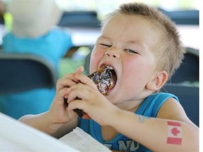 SASKATOON, SK — August 3, 2014 — Brock Decaire takes a mouthful of rubs during Ribfest at Diefenbaker Park in Saskatoon on August 3, 2014. (Michelle Berg / The StarPhoenix)