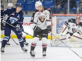 Saskatoon Blades centre Cameron Hebig defects a shot on Vancouver Giants goalie Cody Porter during the second period of WHL action last Sunday.