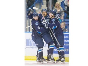 Saskatoon Blades defenceman Tyler Dea, centre, celebrates his first WHL goal with teammates Cameron Hebig, left, and Luke Gingras against the Vancouver Giants during the second period of WHL action on Sunday, Oct. 4, 2015.