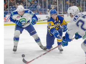 Saskatoon Blades No, 19 Ryan Graham is double teamed by No. 3 Jordan Harris and No. 27 Max LaJoie of the Swift Current Broncos in first period WHL action in Saskatoon, Oct. 9, 2015.