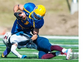 Saskatoon Hilltops Running Back Logan Fischer is tackled by Regina Thunder Defensive Back Marcus Hall at Saskatoon Minor Football Field in Saskatoon on Saturday, Sept. 6, 2014.