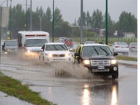 SASKATOON, SK — JULY 28/2015 — A huge puddle in the southbound lanes of Preston Avenue between 108th Street and College Drive was creating spectacular splashes from vehicles, Tuesday, July 28, 2015. (Greg Pender/The StarPhoenix)