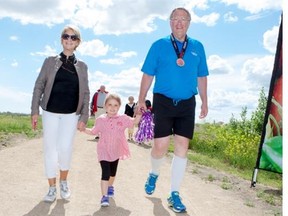 Saskatoon Mayor Don Atchison, right, his wife Mardele, left, and granddaughter Katarina, age 4, walk across the finish line after Atchison completed the Mayor’s Marathon on Sunday. Atchison ran from Whitecap Dakota First Nation to Wanuskewin to raise awareness and money for the Meewasin trail system. (LIAM RICHARDS/The StarPhoenix)