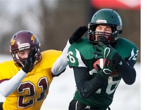 Saskatoon Holy Cross Crusaders  Josh Ewanchyna grabs a pass in front of Regina LeBoldus Golden Suns Karter Parisloff during the 4A Provincial Football championships in Saskatoon, SK. on Saturday, November 15, 2014. The Regina LeBoldus Golden Suns deafen the Saskatoon Holy Cross Crusaders 53-43.