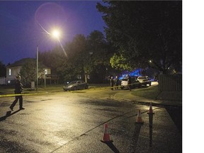 Saskatoon Police Major Crimes investigators secure the scene of a shooting death at the corner of 19th Street West and Avenue Q South Monday evening.