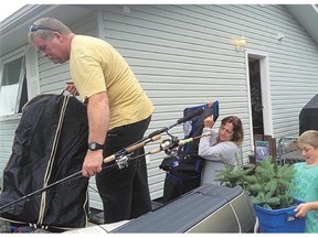 Scott, Michelle and Reae Mackay unpack their belongings Friday as they're reunited at their home in La Ronge.