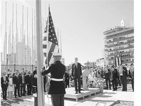 U.S. Secretary of State John Kerry stands with other dignitaries as marines raise the U.S. flag over the newly reopened embassy in Havana on Friday.
