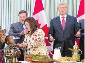 Senator Salma Ataullahjan, centre, helps Muslims break the Ramadan fast as Prime Minister Stephen Harper speaks and Multiculturalism Minister Jason Kenney looks on.