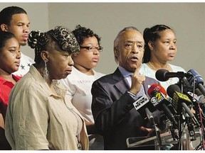 The Rev. Al Sharpton, at microphone, is joined by (clockwise from left) Eric Garner's mother Gwen Carr, daughter Erica Garner, son Eric Garner, daughter Emerald Snipes and wife Esaw Snipes, at a news conference in New York, Tuesday.