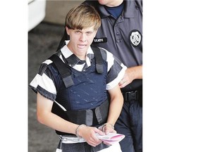 Shooting suspect Dylann Roof is escorted from a courthouse in Shelby, N.C., Thursday. Charleston Mayor Joseph Riley Jr. called the violent act 'pure, pure concentrated evil.'