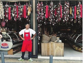 A shopkeeper waits for customers in Athens' central market Monday as higher taxes on everything from coffee to taxis took effect. There are few parts of the economy untouched by the increase in sales taxes to 23 per cent from 13 per cent.