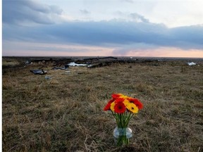 A vase of flowers sits at the remains of a crash scene where three Carrot River teenage where killed when their vehicle was struck by a semi-tracker trailer.