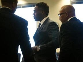 Ultimate Fighting Championship (UFC) star Jon ''Bones" Jones, centre, buttons up his jacket before he pleaded guilty in an April hit-and-run charge, during which a pregnant woman was injured, at the Bernalillo County Second District Courthouse, Tuesday, Sept. 29, 2015, in Albuquerque, N.M. Judge Charles Brown ordered Jones to serve 72 weeks of probation and make 72 speaking appearances to kids. (Marla Brose/The Albuquerque Journal via AP)