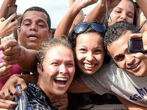 Ultimate Fighting Championship bantamweight champion Ronda Rousey takes photos with fans during a UFC 190 open training session at Pepe Beach on July 29, 2015 in Rio de Janeiro, Brazil. (Photo by Buda Mendes/Zuffa LLC/Zuffa LLC via Getty Images)