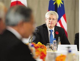 Stephen Harper listens to Barack Obama speak to Trans-Pacific Partnership members last November. Pressure to resolve the proposed treaty quickly is growing.