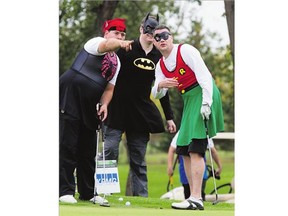 Superheroes Marc Hoffort (Spider-Man) and Clint Gillord (Batman) advise David Engdahl (Robin) on the 18th green at the Saskatoon Golf and Country Club during the READ Saskatoon Charity Golf Fundraiser on Monday.