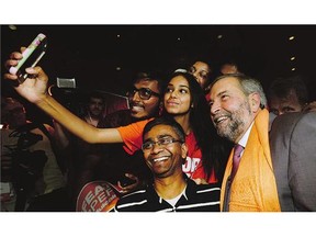 NDP supporters snap selfies with NDP Leader Tom Mulcair at a rally in Toronto on Tuesday. During his speech, Mulcair criticized Liberal Leader Justin Trudeau for voting in favour of a $15-an-hour federal minimum wage and then campaigning against it.