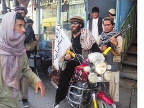 A Taliban fighter sits on his motorcycle adorned with a Taliban flag in a street in Kunduz. The U.S. military carried out an airstrike Tuesday on the northern Afghan city, which was captured by the Taliban the previous day.