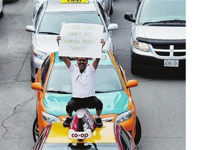 Taxi driver Mubashar Jafri protests the ride-sharing service, Uber, in Toronto in June. Taxi companies nationwide are banding together in an effort to combat Uber.