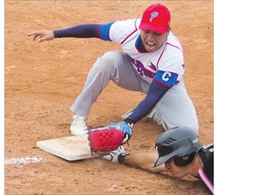 Team New Zealand's Ben Enoka reaches to get safe at third as Philippines' Jesper Cabrera attempts to tag him out during the Men's World Softball Championships at Bob Van Imp park on Monday.