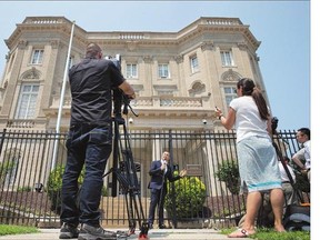 Telemundo news anchor Fausto Malave, centre, reports on Wednesday in front of the Cuban interests section, which serves as the de facto diplomatic mission of Cuba in Washington, D.C., on Wednesday. U.S. President Barack Obama said Wednesday the U.S. and Cuba plan to reopen their embassies.