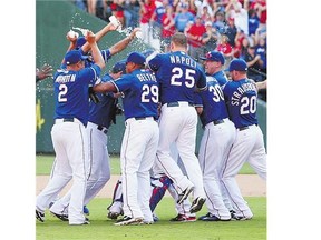 The Texas Rangers celebrate after defeating the Los Angeles Angels 9-2 to clinch the AL West title Sunday.