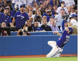 Third baseman Josh Donaldson of the Blue Jays slides to make the catch as Kansas City Royals' Kendrys Morales fouls out during the sixth inning in Game 4 of the American League Championship Series on Tuesday in Toronto.