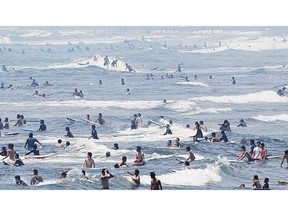 In this July 15, 2013 photo, surfers wait for waves at Shonan beach in Fujisawa, west of Tokyo. Youth-oriented sports such as surfing and skateboarding were among five recommendations made by Japanese organizers Monday for the 2020 Tokyo Olympics.