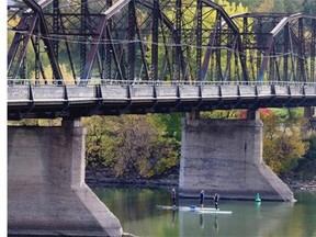 File Photo. Three paddle boarders go under the Victoria Bridge on a sunny day on the river in September.