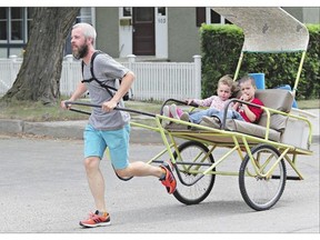 Todd Lyons pulls his children Georgia and Owen in his Nutana neighbourhood in the rickshaw he built. Rickshaws date to the 19th century and are a common form of transportation in Asia.