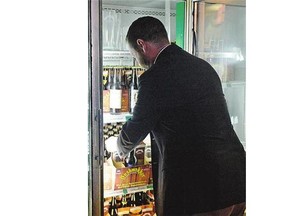 Todd MacKay of the Canadian Taxpayers Federation, grabs a case of beer from the Bushwackers off-sale in Regina Friday.