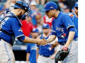 Toronto Blue Jays catcher Russell Martin and relief pitcher Roberto Osuna celebrate beating the Texas Rangers 8-4 at Game 4 of baseball's American League Division Series Monday.