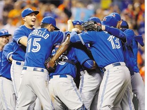 Toronto Blue Jays members celebrate after winning the first game of a doubleheader, 15-2, against the Baltimore Orioles to clinch the American League East Division title.