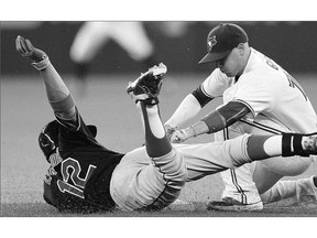 Toronto Blue Jays' Ryan Goins makes the tag on Cleveland Indians' Francisco Lindor at second base during the eighth inning in Toronto on Tuesday.