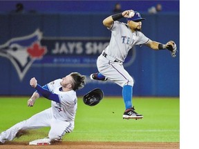 Toronto Blue Jays third baseman Josh Donaldson takes a hit to the head from a leaping Texas Rangers second baseman Rougned Odor during Game 1 of their American League Division Series Thursday in Toronto. Donaldson had to leave the game because of the concussion protocol. The Rangers won 5-3.