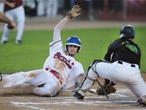 Trevor Fonseca of Team B.C. slides in safe at home in front of Team Saskatchewan catcher Bryce Rueve.