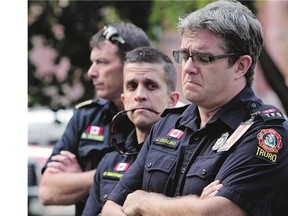 Truro firefighter Josh Chisliing, right, fights back tears as he listens to Police Chief Dave MacNeil make a statement regarding slain Truro Police Officer and volunteer firefighter Catherine Campbell, in Truro, N.S. on Wednesday.
