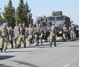 Turkish soldiers walk to their position on the Turkish side of the border in Suruc, Turkey on Friday, near the Syrian town of Kobani.