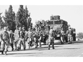 Turkish soldiers walk to their position on the Turkish side of the border in Suruc, Turkey, last June, near the Syrian town of Kobani. Ankara increased its co-operation with a U.S.-led military coalition last month, after an ISIL-linked suicide attack killed 33 students in Suruc.