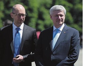 Ukrainian Prime Minister Arseniy Yatsenyuk, pictured with Prime Minister Stephen Harper in Kyiv last, will lead nearly a dozen senior Ukrainian officials to Ottawa with an eye to finishing a free-trade agreement with Canada.