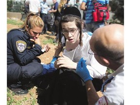 An ultra-Orthodox Jewish teenager is treated by a medical team Friday after he was stabbed by a Palestinian man in Jerusalem as random attacks continue in Israel.