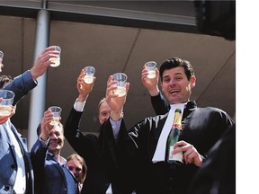 Urgenda Foundation lawyer Roger Cox, right, proposes a toast on the steps of the courthouse in a scene setup by TV in The Hague on Wednesday. A Dutch court has ordered the government to cut the country's greenhouse gas emissions by at least 25 per cent by 2020 in a groundbreaking climate case that activists hope will set a worldwide precedent.