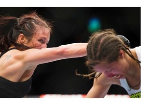 Valerie Letourneau (red) throws a punch at Elizabeth Phillips (blue) in a women’s bantamweight bout during UFC 174 at Rogers Arena, Vancouver.