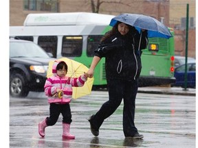 File Photo. A very wet day in Saskatoon as pedestrians downtown cover up from the rain.