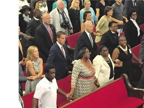 U.S. Vice-President Joe Biden, centre, with son and daughter-in-law Hunter and Kathleen Biden, to his right, sing We Shall Overcome while joining hands with Emanuel AME Church members on Sunday in Charleston, S.C.