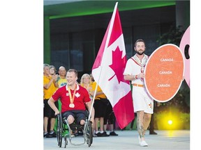 Wheelchair rugby player Zak Madell carries the flag during the closing ceremony of the Parapan Am Games in Toronto Saturday. Canada finished second to Brazil in the medal count.