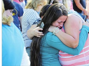 A woman is comforted as friends and family wait for students at the local fairgrounds after a shooting at Umpqua Community College in Roseburg, Ore., on Thursday. A gunman opened re at the college, killing 10 people before dying in a shootout with police. See story on Page D6.