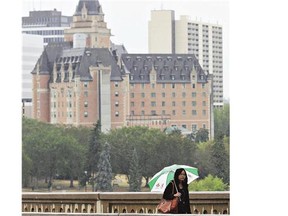 A woman tries to keep dry as Saskatoon gets some rare rainfall on Monday.